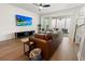 Spacious living room with hardwood floors, leather sofa, and access to a screened porch at 111 Crimson St, Summerville, SC 29486