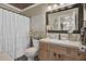 Updated bathroom with wood vanity, white toilet and shower with white ruffled curtain at 125 Trickle Dr, Summerville, SC 29483