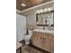 Updated bathroom with wood vanity, white toilet and shower with white ruffled curtain at 125 Trickle Dr, Summerville, SC 29483