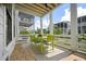 Covered porch with bright lime green outdoor table and seating and privacy fence at 1474 Mizzen Aly, Johns Island, SC 29455