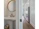 Traditional powder room with pedestal sink, round mirror and hardwood floors at 1474 Mizzen Aly, Johns Island, SC 29455