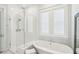 Spa-like bathroom with a soaking tub, walk-in shower, and white tile at 1680 Banning St, Mount Pleasant, SC 29466