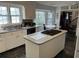 Kitchen with white cabinets, island with cooktop, and large windows at 19 Fort Royal Ave, Charleston, SC 29407
