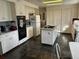 Galley style kitchen, white cabinets, island with gas cooktop, dark flooring at 19 Fort Royal Ave, Charleston, SC 29407