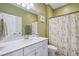 bathroom with white vanity, green walls, and a whimsical shower curtain at 2202 St Johns Woods Pkwy, Johns Island, SC 29455