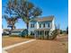 Two-story light blue house with a front porch and landscaped yard at 2202 St Johns Woods Pkwy, Johns Island, SC 29455