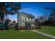 Two-story light blue house with a front porch, lit up at night at 2202 St Johns Woods Pkwy, Johns Island, SC 29455