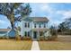 Two-story light blue house with a front porch and landscaped yard at 2202 St Johns Woods Pkwy, Johns Island, SC 29455