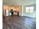 Open concept kitchen with stainless steel appliances and gray vinyl plank flooring at 2203 Scarlett Maple St, Summerville, SC 29486