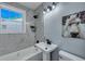 Updated bathroom with marble tile, white vanity, and bathtub at 2268 Bailey Dr, North Charleston, SC 29405