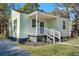 Charming light green house with white porch and steps, well-maintained landscaping at 2268 Bailey Dr, North Charleston, SC 29405