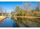 Serene pond with tree reflections and houses in background at 2311 Tall Sail Dr # B, Charleston, SC 29414