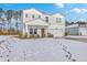 Two-story house with a white garage door and porch swing, freshly covered in snow at 261 Firewheel Ct, Summerville, SC 29486