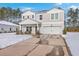 Two-story house with a white garage door and porch swing, freshly covered in snow at 261 Firewheel Ct, Summerville, SC 29486