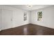 Bright room with dark floors, modern lighting fixture, and views through two large windows at 2889 Alabama Drive, North Charleston, SC 29405