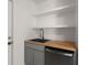Kitchen with wood counters, stainless steel dishwasher and sink, and white floating shelves at 2889 Alabama Drive, North Charleston, SC 29405