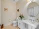 Neat half bathroom with pedestal sink and round mirror, alongside a toilet and floral arrangement at 355 Cooper River Dr, Mount Pleasant, SC 29464