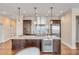 Kitchen island featuring stainless steel fridge and sink, pendant lighting, and hardwood floors at 355 Cooper River Dr, Mount Pleasant, SC 29464