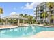 Resort-style pool with a covered bar area, lounge chairs, and lush tropical landscaping adjacent to the building at 355 Cooper River Dr, Mount Pleasant, SC 29464