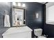 Powder room with dark shiplap walls and a white vanity at 3906 Waterway Blvd, Isle of Palms, SC 29451