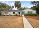 Charming white brick ranch home with a light blue door and manicured lawn at 3906 Waterway Blvd, Isle of Palms, SC 29451