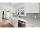 Modern kitchen with white cabinets, quartz countertops, and a farmhouse sink at 3906 Waterway Blvd, Isle of Palms, SC 29451