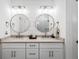 Bathroom with double sinks, round mirrors, and white shaker cabinets at 391 Wappoo Trace Ln, Summerville, SC 29486
