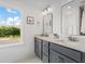 Modern bathroom with double vanity, large mirror and a window at 391 Wappoo Trace Ln, Summerville, SC 29486