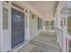 Inviting front porch with wood flooring and black front door at 4816 8Th Tee Dr, Hollywood, SC 29449