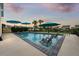 Inviting backyard pool with multiple umbrellas and chairs at sunset at 531 Switchgrass Dr, Summerville, SC 29486