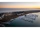 Aerial view of waterfront homes and a marina with many boats at sunset at 67 W We 10Th St # A-8, Folly Beach, SC 29439