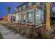 Two-story light blue house with a front porch, landscaping, and palm trees at 711 Blueway Ave, Summerville, SC 29486