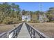 Wooden walkway over calm water toward a house in the distance at 1034 Bradbury Ln, Charleston, SC 29492