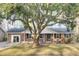 Brick ranch home with a covered porch, mature trees, and a well-manicured lawn at 111 Terry Ave, Summerville, SC 29485