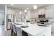 Kitchen island with seating, white cabinets, and stainless steel appliances at 132 Lilac Grove Way, Summerville, SC 29486