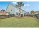 Landscaped backyard with a wooden fence, palm tree, and pergola at 1455 Red Tide Rd, Mount Pleasant, SC 29466