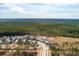 A distant aerial view of a neighborhood featuring a gray two-story home with a beautiful forest in the background at 200 Clearblue Loop, Summerville, SC 29486