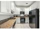 Galley kitchen with granite countertops and white cabinets at 21 George St # 114, Charleston, SC 29401