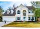 Two-story yellow house with blue shutters, a white garage, and a well-maintained lawn at 212 Thomaston Ave, Summerville, SC 29485