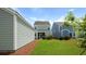 View of the home's backyard featuring a screened porch, green grass and tasteful landscaping at 215 Terrace View Dr, Summerville, SC 29486