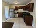 Galley kitchen with dark wood cabinets, stainless steel appliances, and tile floor at 292 Fleming Rd # C, Charleston, SC 29412