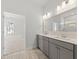 Double vanity bathroom with gray cabinets and a large mirror reflecting a shower at 349 Trailmore Ln, Summerville, SC 29486