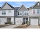 Two-story townhouses with gray and blue siding, white garage doors, and landscaping at 396 Painted Lady Ln, Goose Creek, SC 29445