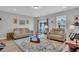 Living room with two beige sofas, a coffee table, and access to a patio at 396 Painted Lady Ln, Goose Creek, SC 29445