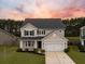 Two-story house with beige siding, a white garage door, and a large backyard at 401 Huckleberry Ct, Summerville, SC 29486