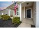 Front porch with white columns, black door, and American flag at 401 Huckleberry Ct, Summerville, SC 29486