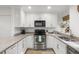 White kitchen with stainless steel appliances and granite countertops at 4545 Park Lake Dr, Kiawah Island, SC 29455