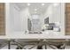 White kitchen with breakfast bar, stainless steel appliances, and subway tile backsplash at 4995 Green Dolphin Way, Kiawah Island, SC 29455