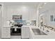 Modern white kitchen with stainless steel appliances and quartz countertops at 4995 Green Dolphin Way, Kiawah Island, SC 29455