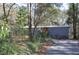 Gray mobile home with red door, steps, and American flag, nestled in a wooded setting at 6321 Bears Bluff Rd, Wadmalaw Island, SC 29487